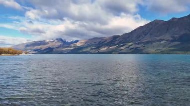 Glenorchy, Yeni Zelanda 'da dinamik bulutlar ve güneş ışığı altında dağ zeminli sakin bir göl. Canlı gün ışığında yakalandılar.