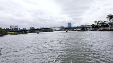 Bir tekne köprünün altındaki nehirden geçiyor.