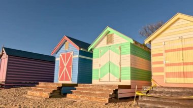 Renkli sahil kulübeleri. Suyun üzerinde gün doğumu.