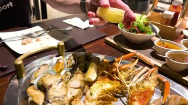 Lezzetli deniz ürünleri ve et tabağı servis ediliyor.