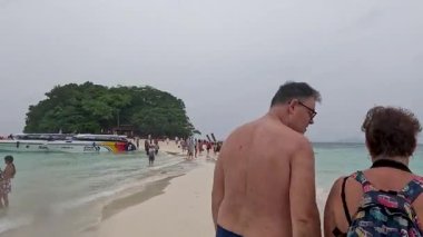 Turistler sahilde bir günün tadını çıkarırlar.