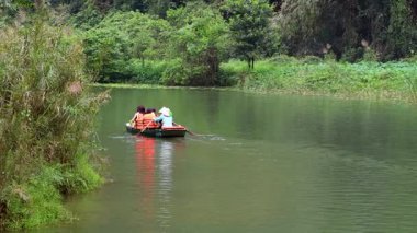 Sakin bir nehirde kürek çeken insanlar