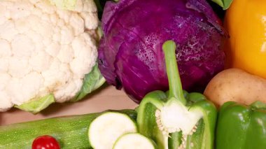 Canlı bir taze sebze çeşidi sanatsal olarak düzenlenmiş, çeşitli renk ve dokuları doğal ışıklandırmada sergiliyor.