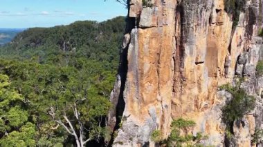 Nimbin Kayaları 'nın hava görüntüleri açık mavi gökyüzünün altında yükselen kayalıkları ve yemyeşil ormanları gösteriyor.