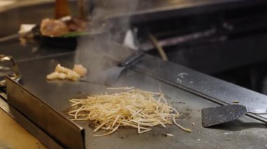 Şef et ve sebzeleri ustalıkla pişirir..