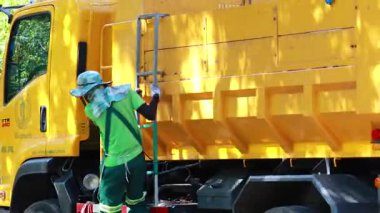 Şehir parkında çöpleri toplamak için işbirliği yapan işçiler