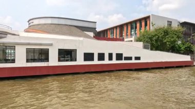 Bangkok 'ta nehir kıyısında dairesel mimarisi olan modern bir bina. Durgun suyla gün ışığında ele geçirildi.