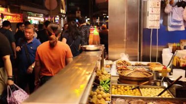 Kalabalık hareketli sokak yemekleri pazarının keyfini çıkarıyor