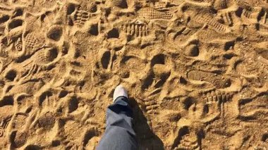 Kumda ayak sesleri, sahil kulübeleri, yürüyen insanlar.