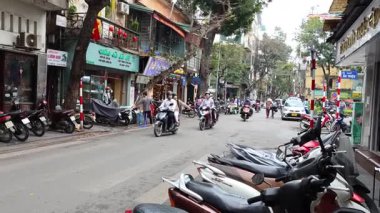 Kalabalık bir caddede motosikletler ve yayalar