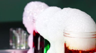 Büyüleyici bir bilim deneyi kuru buzu sergiliyor renkli sıvılarda köpük çıkarıyor, kimyasal reaksiyonları ve görsel efektleri vurguluyor.