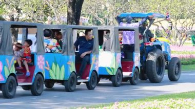 Ziyaretçiler çiçek bahçelerinde traktör yolculuğunun keyfini çıkarıyorlar.