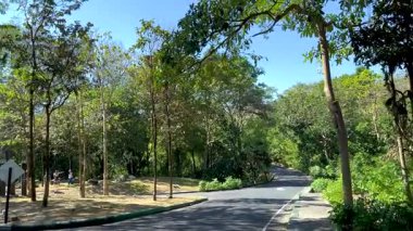 Ziyaretçiler Chonburi 'deki yemyeşil hayvanat bahçesi çevresini keşfediyorlar.