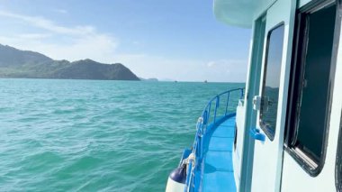 Ko Racha Yai yakınlarındaki turkuaz sularda bir tekne süzülüyor, açık gökyüzünün altında, Phuket 'in huzurlu güzelliğini yakalıyor.