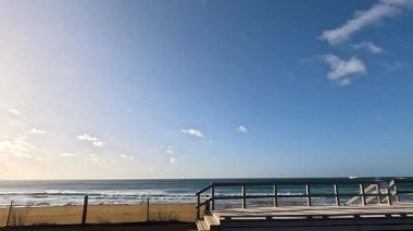 Berrak gökyüzü ile sakin bir sahil sahnesi