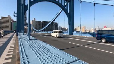 Büyük mavi çelik bir köprünün üzerinden trafik akışı