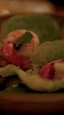 Bir tabakta karides miang kham yakın çekim, yumuşak, sıcak ışık ve sığ alan derinliği ile yakalandı