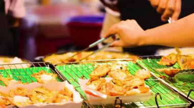 Pazarda kıtır kıtır deniz ürünleri krepleri hazırlayan eller.