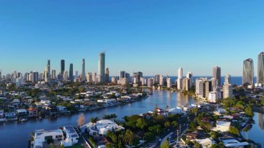 İnsansız hava aracı günbatımında Gold Coast 'un ufuk çizgisinin ve su yollarının dinamik görüntülerini yakalıyor, kentsel mimariyi ve dingin doğal güzelliği vurguluyor.