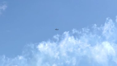 Bir Boeing C-17 Globemaster III açık mavi gökyüzünde Geelong, Victoria 'da dağınık bulutlarla uçuyor.