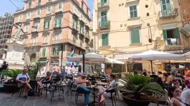 İnsanlar kafede güneşli bir günün tadını çıkarıyorlar.