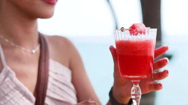 Açık havada taze karpuz içen bir kadın.