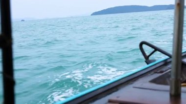 Tayland, Krabi yakınlarındaki adalarda turkuaz sularda seyahat eden bir tekne.
