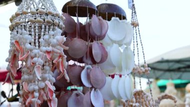 Canlı bir deniz kabuğu yavaşça sallanıyor ve hareketli bir Phuket pazarının özünü yakalıyor. Doğal ışıklandırma onun karmaşık tasarımını vurguluyor