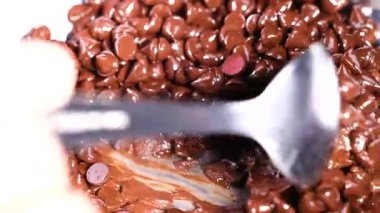 Çikolata parçalarını kaşıkla karıştırıyorum.