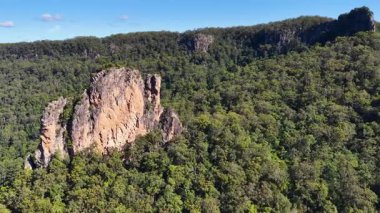 İHA görüntüleri, açık mavi gökyüzünün altında yoğun yeşilliklerle çevrili ikonik Nimbin Kayalarını yakalıyor.