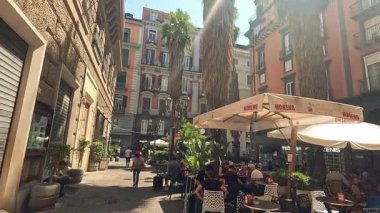 İnsanlar kafede güneşli bir günün tadını çıkarıyorlar.