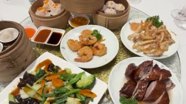 Dönen tembel Susan 'ın üzerinde canlı bir Dim Sum tabağı, karides, kızarmış ördek ve kızarmış sebzeler.