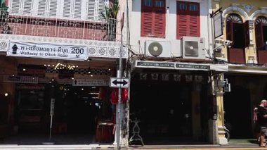 İnsanlar Phuket 'teki renkli binaların önünden geçiyor.