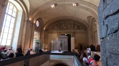 İnsanlar müzenin merdivenlerinden inip çıkıyorlar.