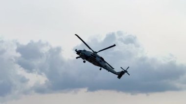 Bir Sikorsky SH-60 Seahawk Geelong, Avustralya 'daki Avalon Hava Gösterisi sırasında bulutlu bir gökyüzüne karşı hava manevraları gerçekleştirir.