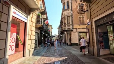 İnsanlar kaldırım taşlı bir sokakta yürüyor.