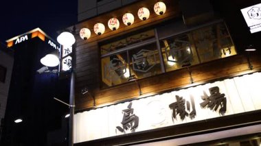 Yayalar gece canlı kentsel bir alanda yürüyorlar.