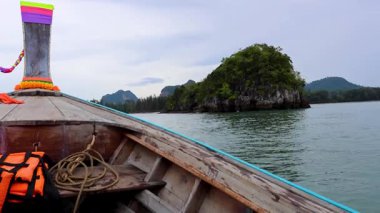 Tahta tekne yemyeşil ada manzarasına yaklaşıyor.