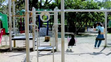 Çocuklar Rama 9 Park 'ta salıncaktan hoşlanıyor.