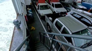 Tayland, Koh Samui yakınlarındaki bir feribot güvertesinde araçlar. Sakin denizler ve bulutlu gökyüzü sakin bir hava kattı.