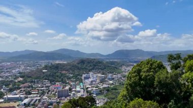 Drone görüntüleri Phuket 'in şehir manzarasını açık gökyüzünün altında yemyeşil ve uzak dağlarla yakalıyor.