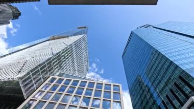 Kırmızı otobüs modern binaların önünden geçiyor.