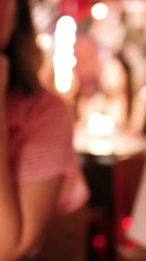 İki insan, neşeli ve neşeli bir atmosfer yaratmak için canlı, sıcak bir restoranda kadeh tokuşturuyor.