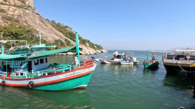 Sakin bir kıyı koyuna demirlemiş renkli tekneler.