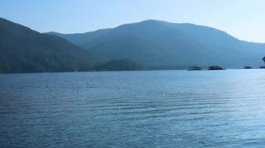 Tekneli ve dağ zeminli sakin su