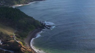 Avustralya, Byron Körfezi 'nin sakin kıyı şeridini gösteren hava görüntüleri yumuşak gün ışığı altında yemyeşil ve yumuşak okyanus dalgalarını vurgular.