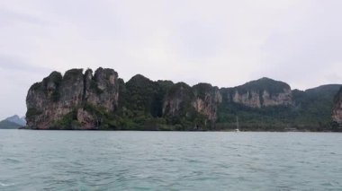 Uzun kuyruklu tekne kayalık adaları ve yemyeşil alanları geçiyor.