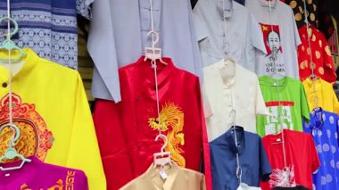 Çeşitli gömlekler askıda sergileniyor.