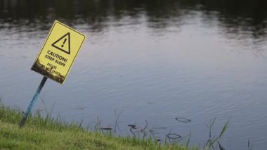 Sarı uyarı işareti usulca suda sallanıyor..