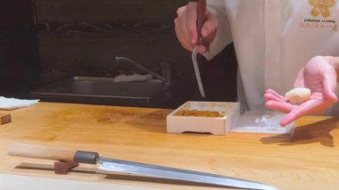 Şef usta bir şekilde uni nigiri sushi hazırlar.